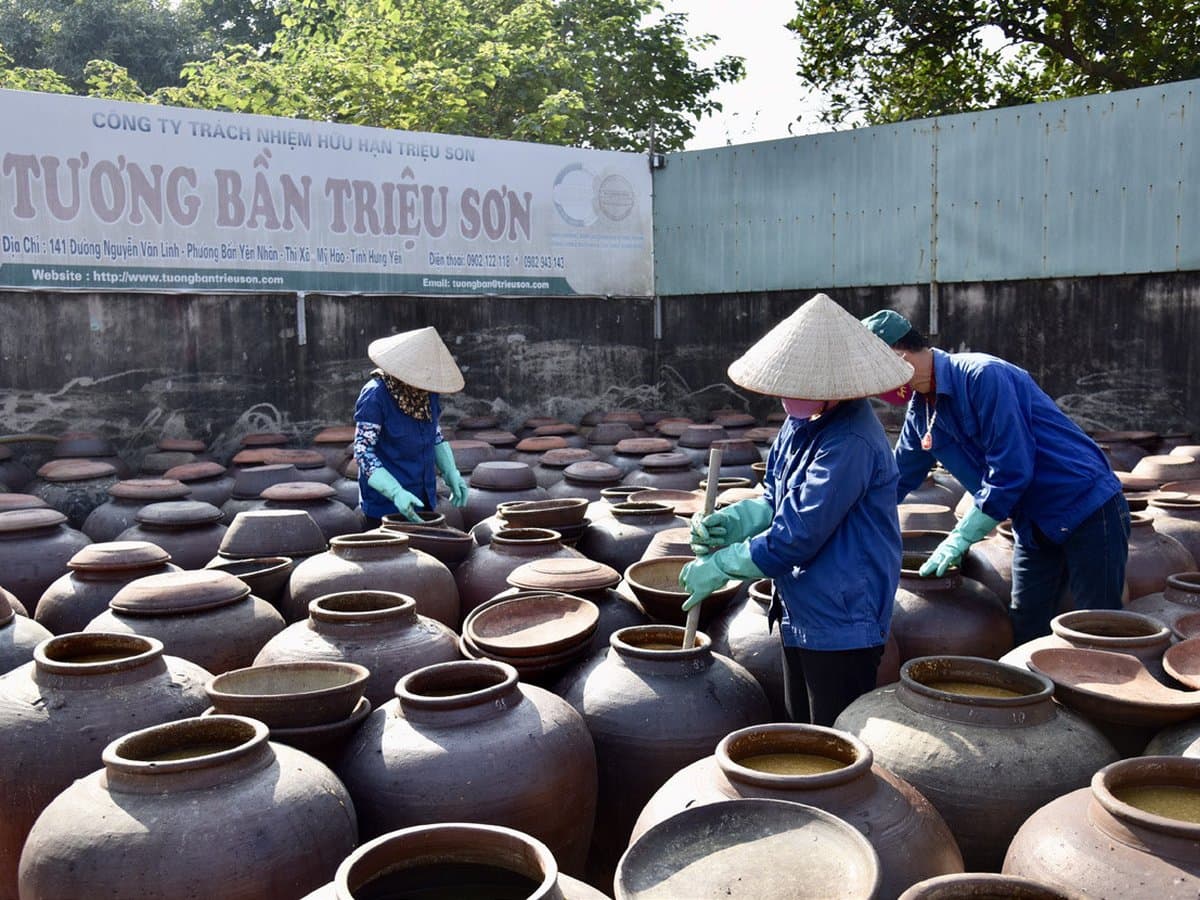 Người làm tương bên chum ủ tương bần Triệu Sơn