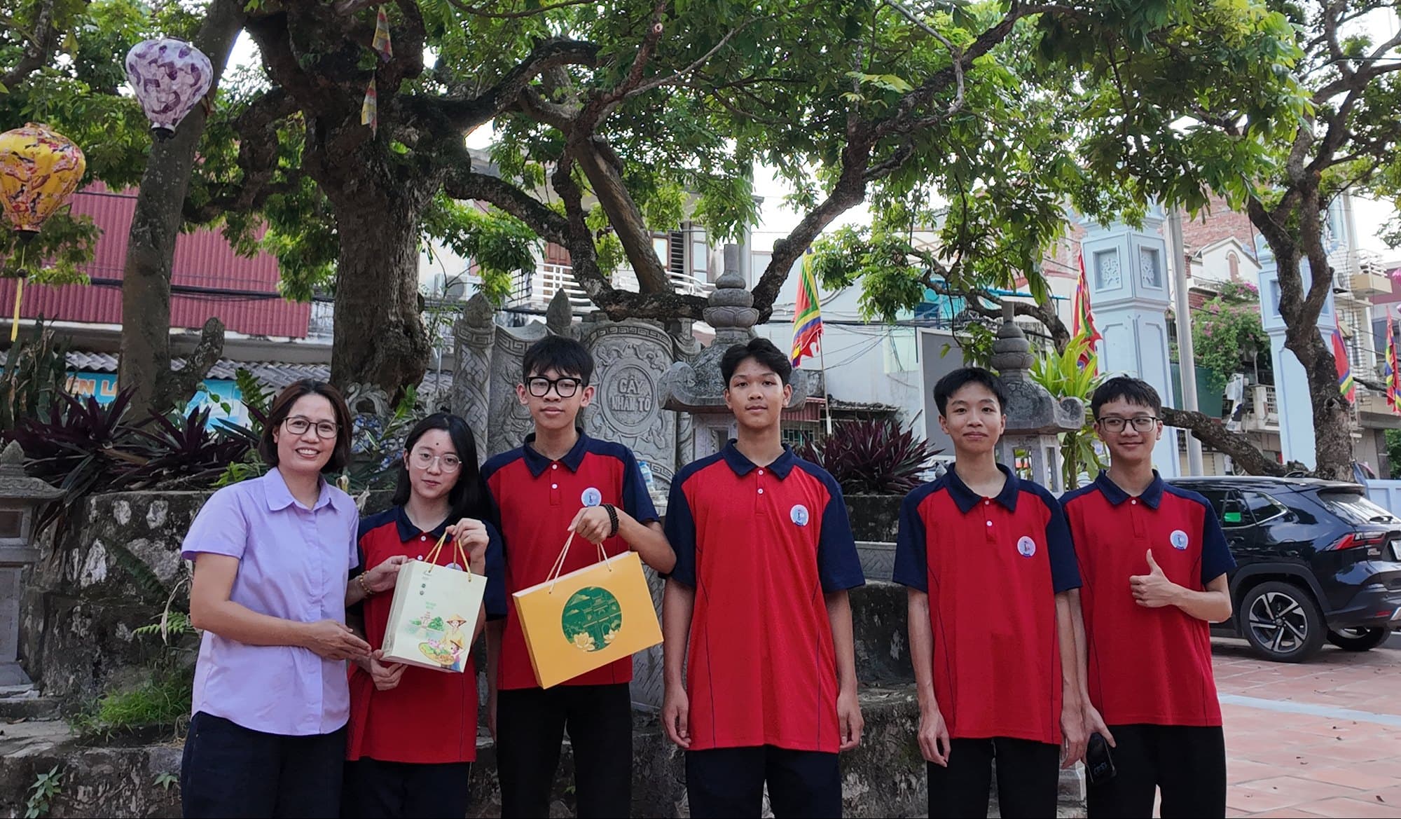 Cô Trần Thị Ngoan và nhóm dự án trước bia Cây nhãn Tổ, chùa Hiến